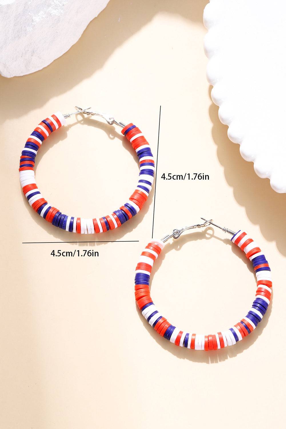 Colorful hoop earrings with measurements on a beige background