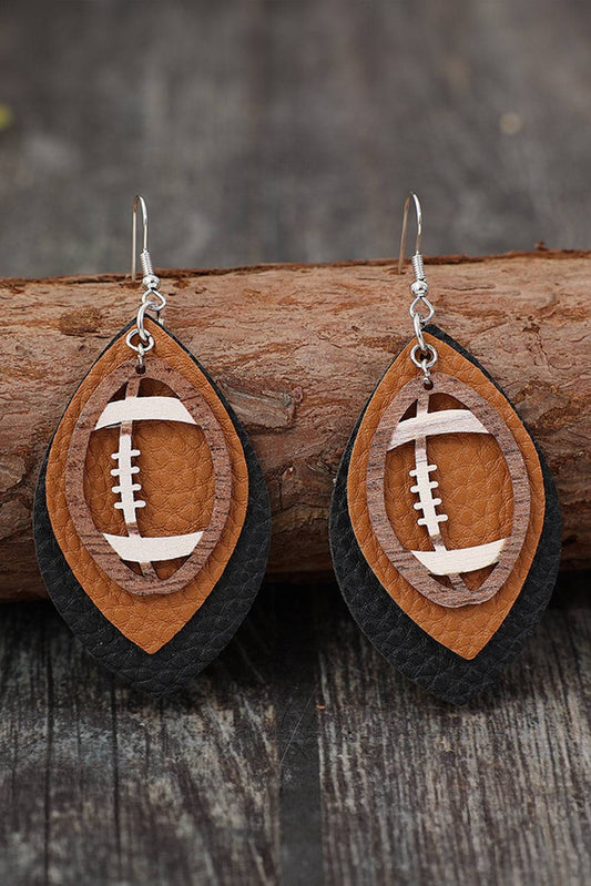 Wooden football-shaped earrings on a wooden surface with a blurred background
