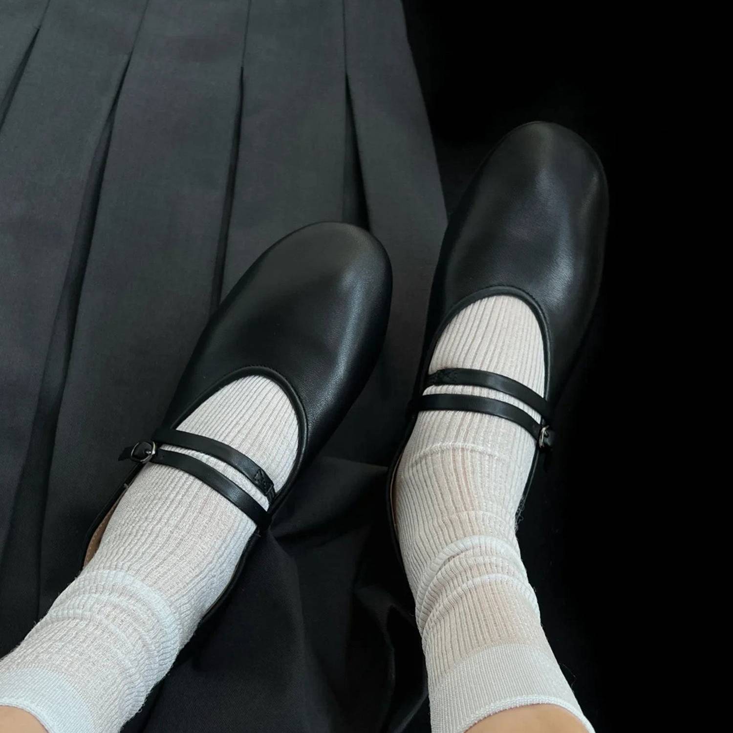 Black shoes with white socks and black stripes on a black background