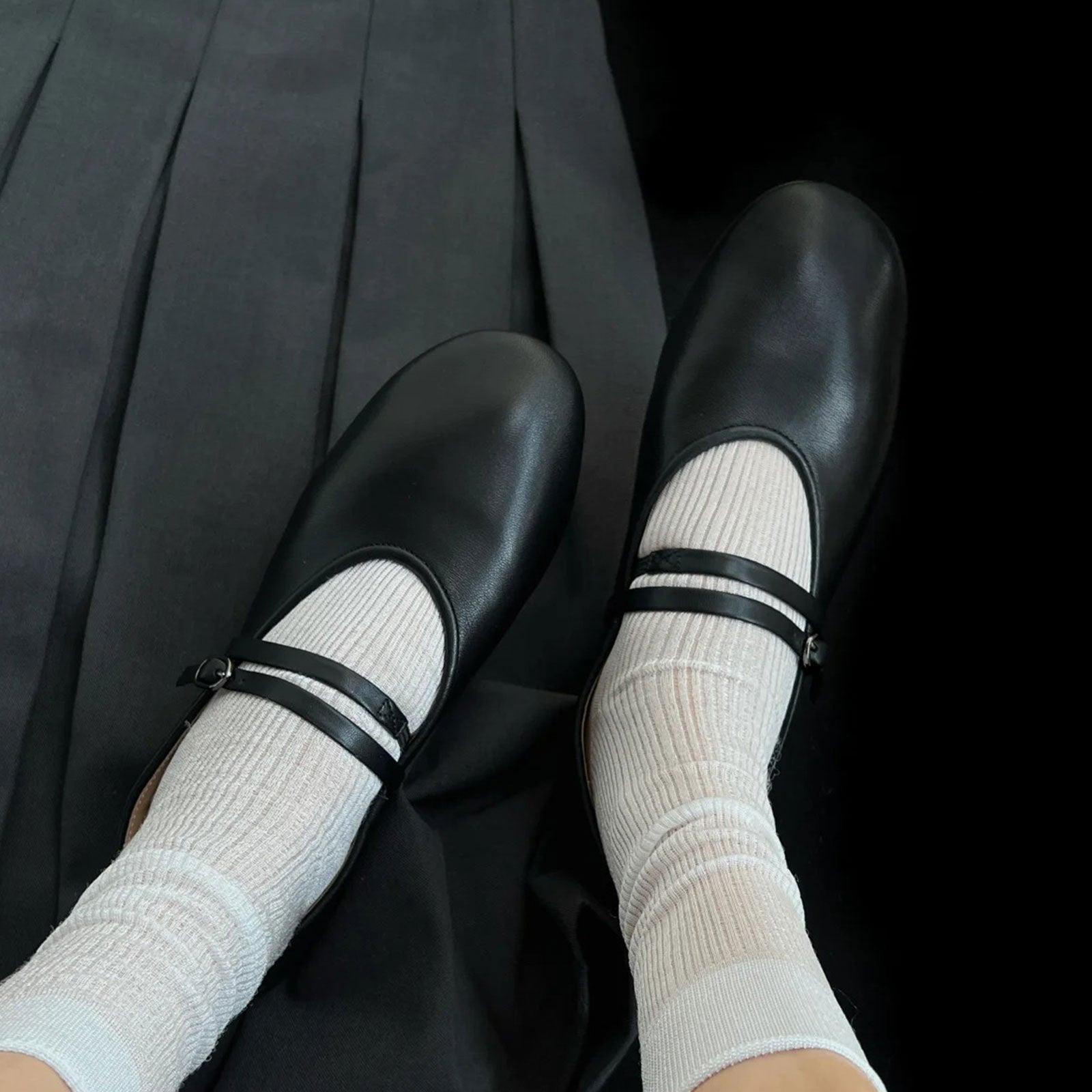 Black shoes with white socks and black stripes on a black background