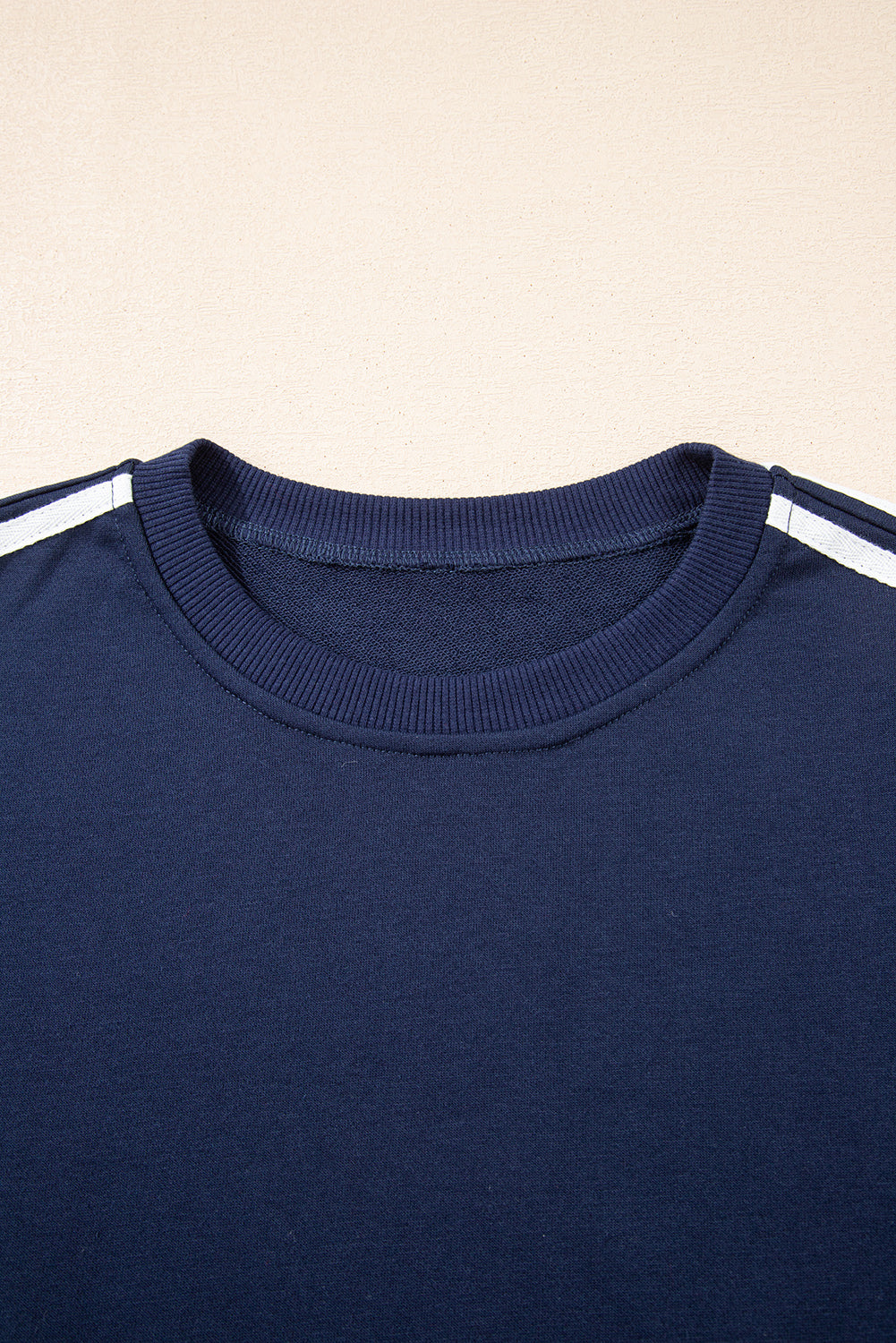 Navy blue shirt with white stripes on a beige background