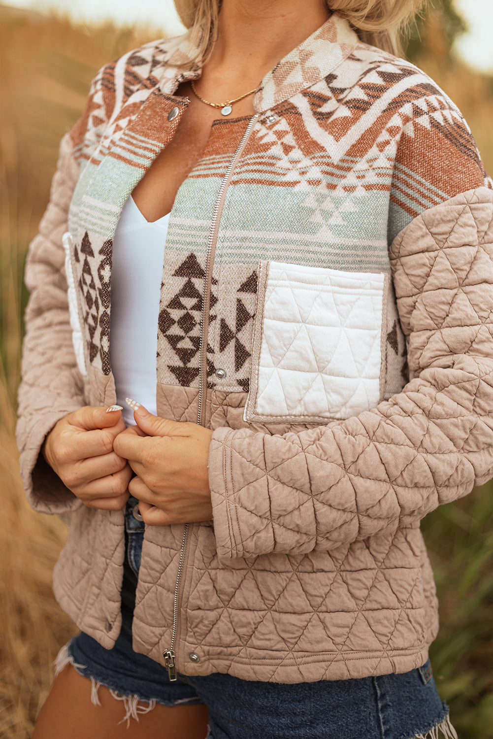 Person wearing a patterned quilted jacket in an outdoor setting