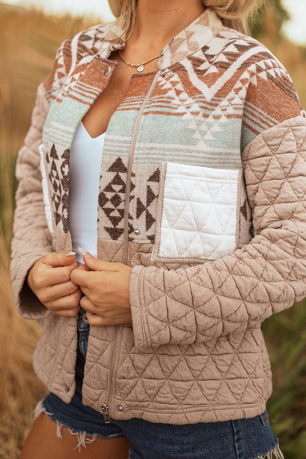Person wearing a patterned quilted jacket in an outdoor setting