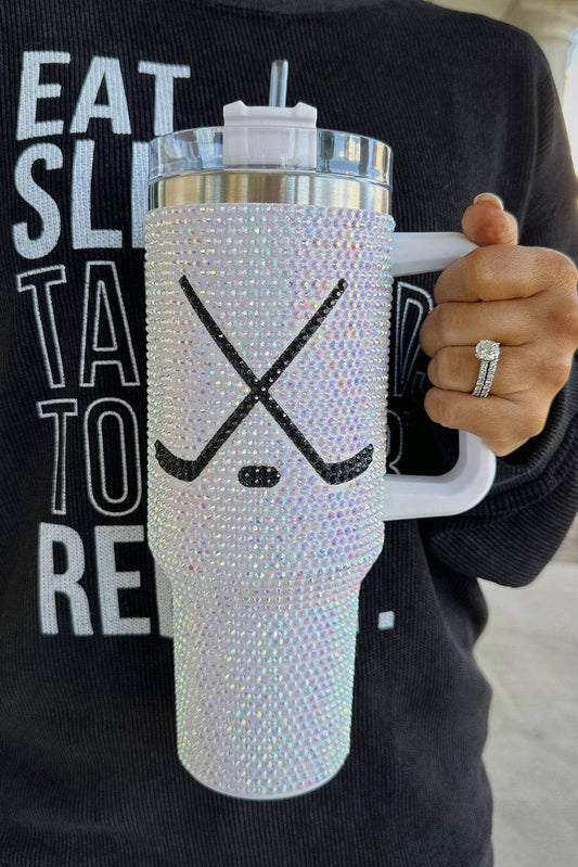 Person holding a blinged-out tumbler with a black and white design.