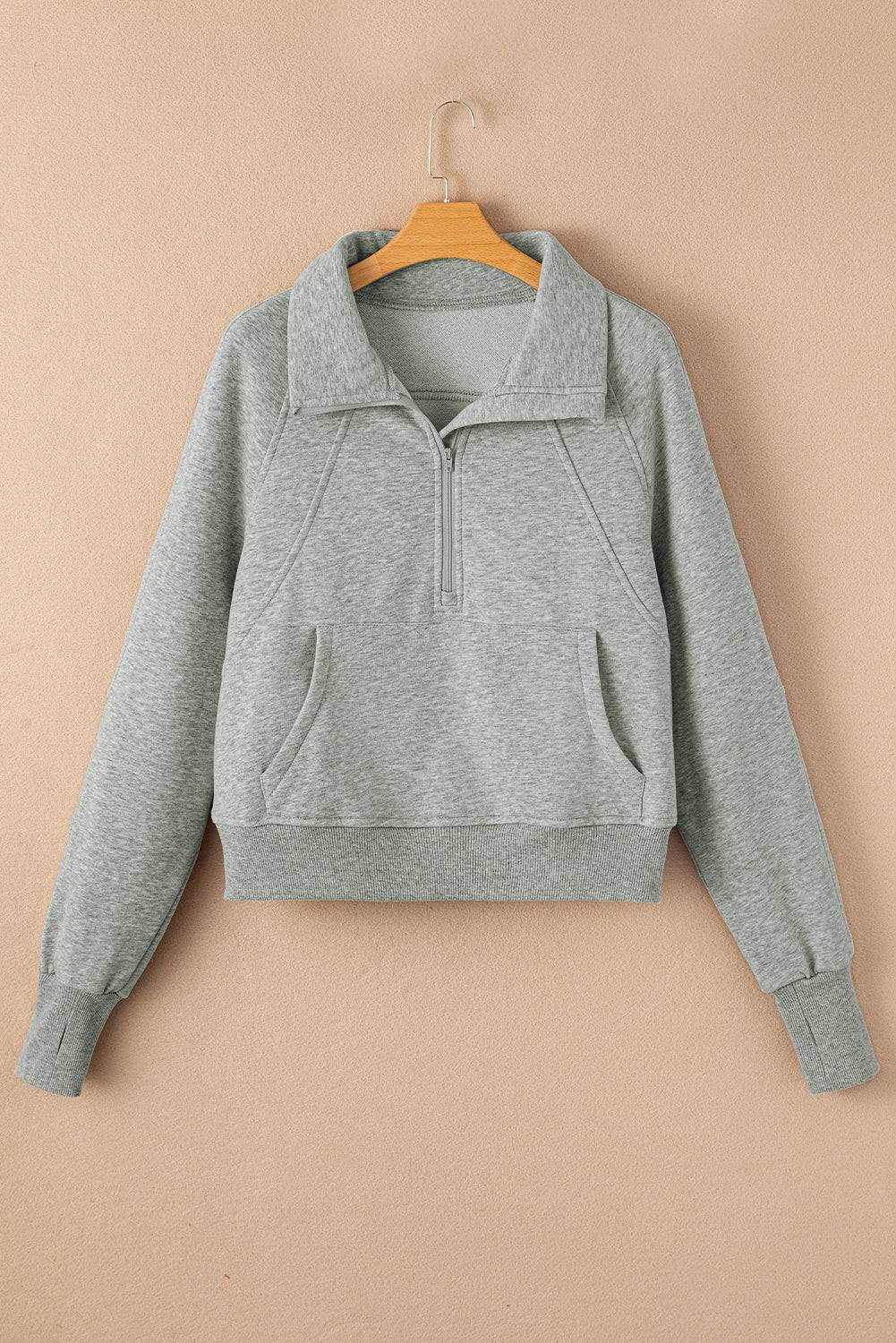 Gray sweatshirt on a hanger against a beige background