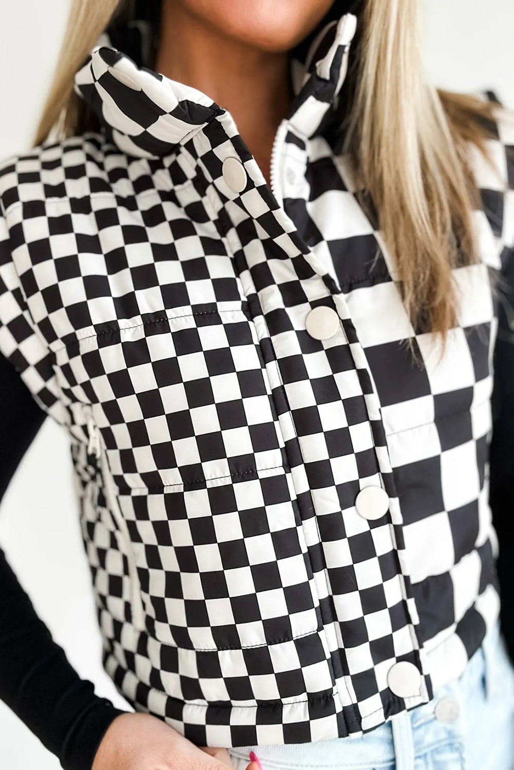 Person wearing a black and white checkered shirt with a blurred background