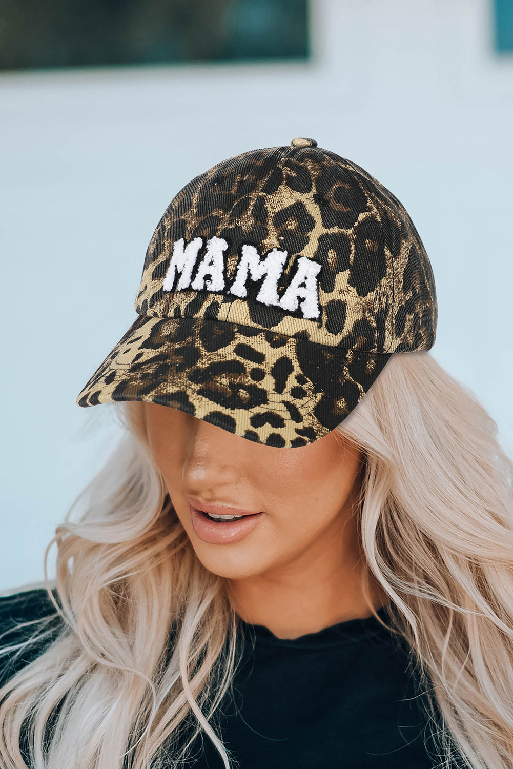 Person wearing a leopard print cap with 'MAMA' text against a light background