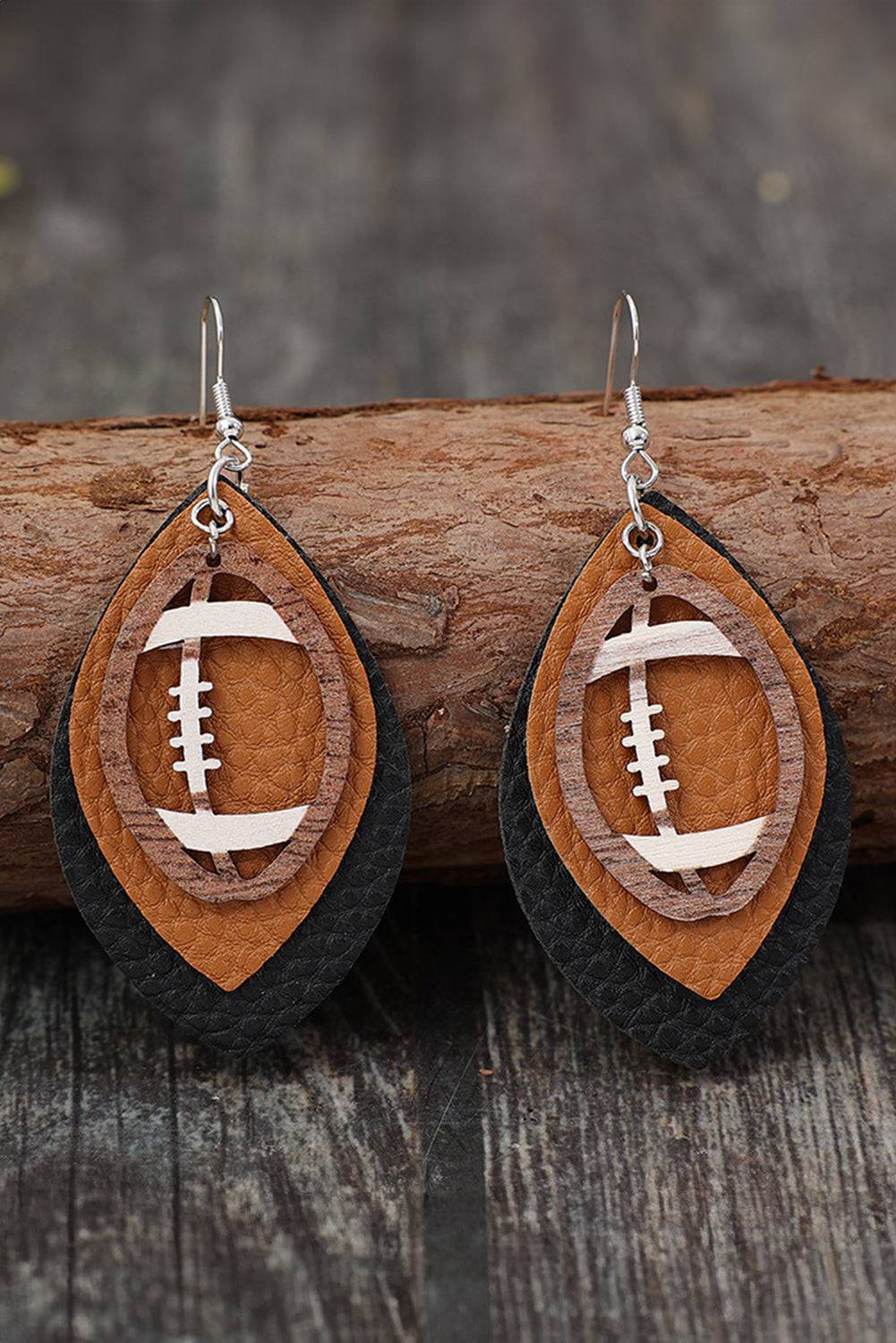 Wooden football-shaped earrings on a wooden surface with a blurred background