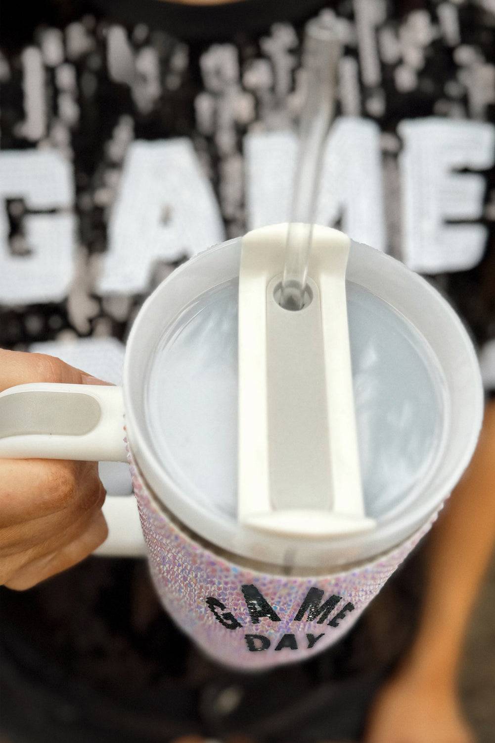Person holding a mug with a 'Game Day' design against a blurred background