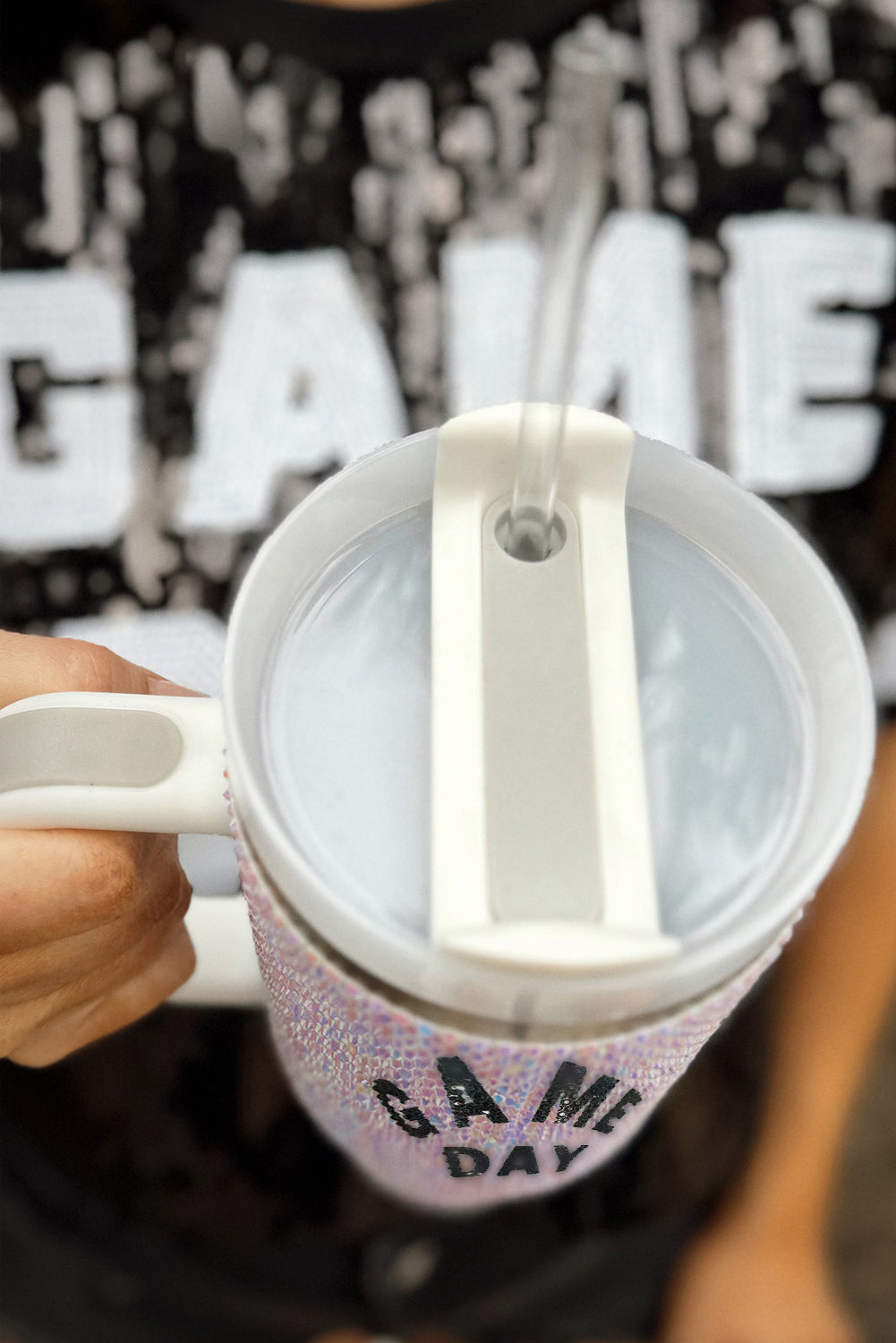 Person holding a mug with a 'Game Day' design against a blurred background