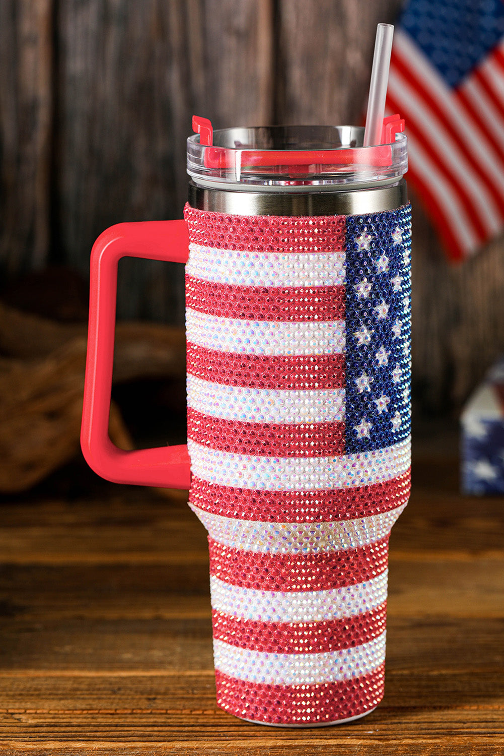 Tumbler with American flag design and red handle on a wooden surface