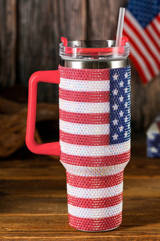 Tumbler with American flag design and red handle on a wooden surface