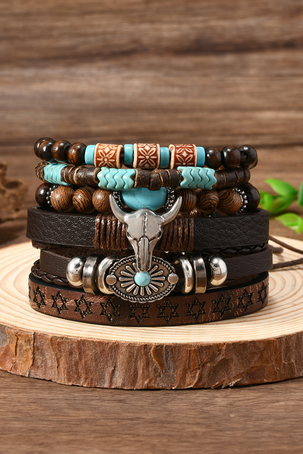 Stack of leather and beaded bracelets with decorative elements on a wooden surface