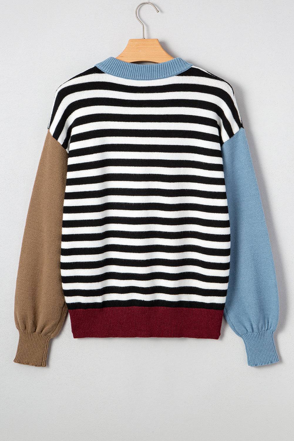 Multicolored striped sweater on a hanger against a light gray background