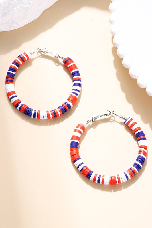 Pair of hoop earrings with red, white, and blue striped design on a beige background