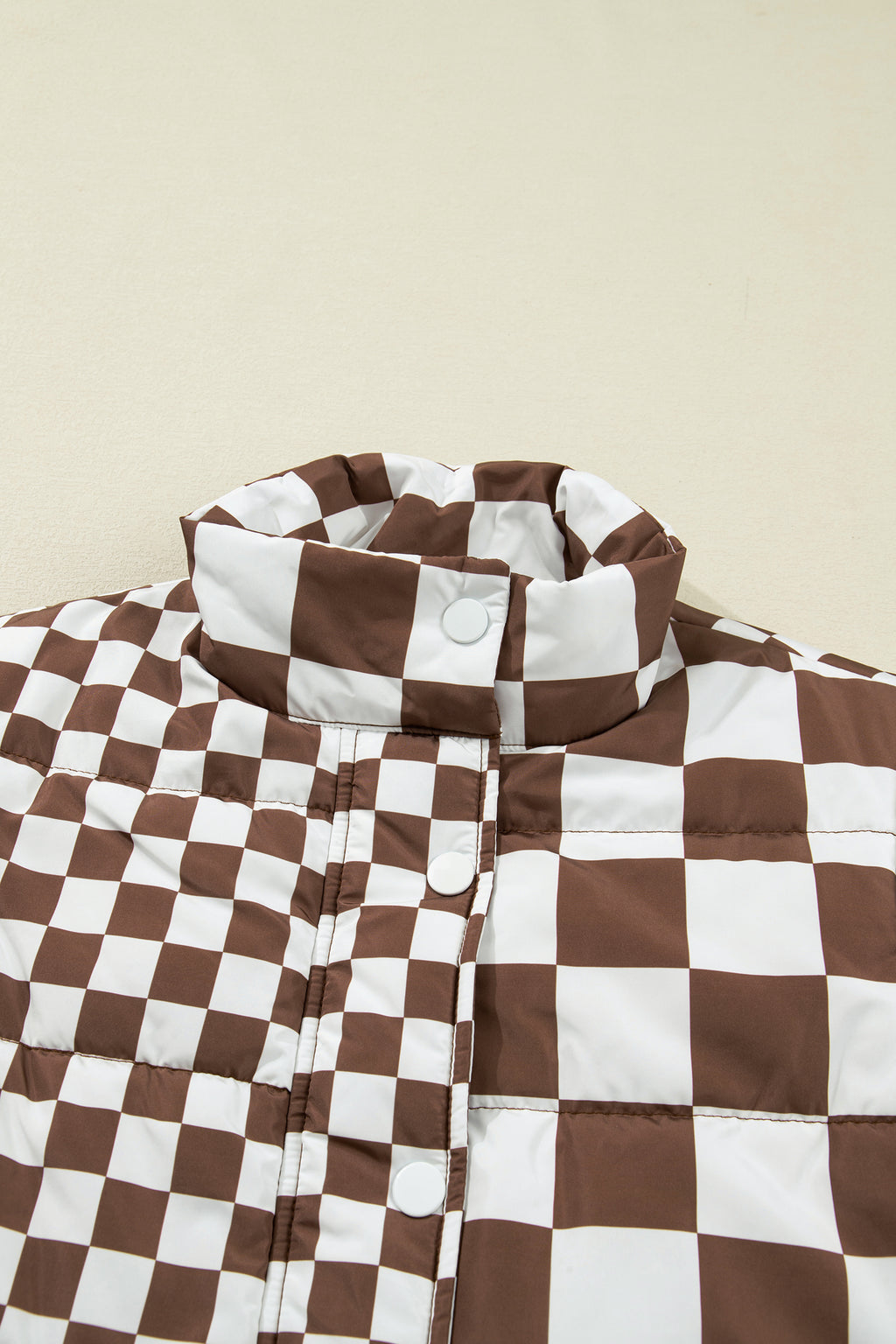 Brown and white checkered jacket on a beige background
