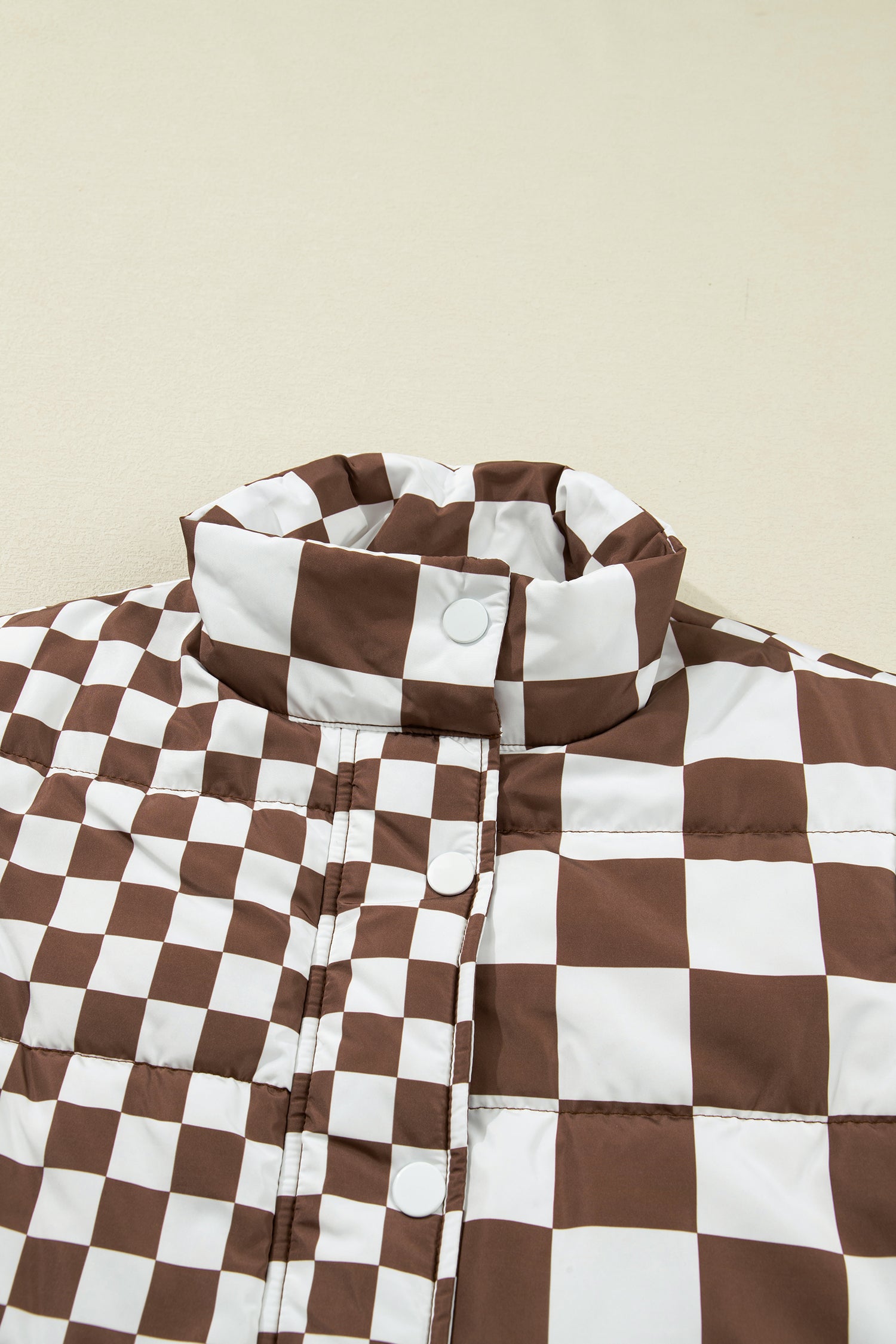 Brown and white checkered jacket on a beige background