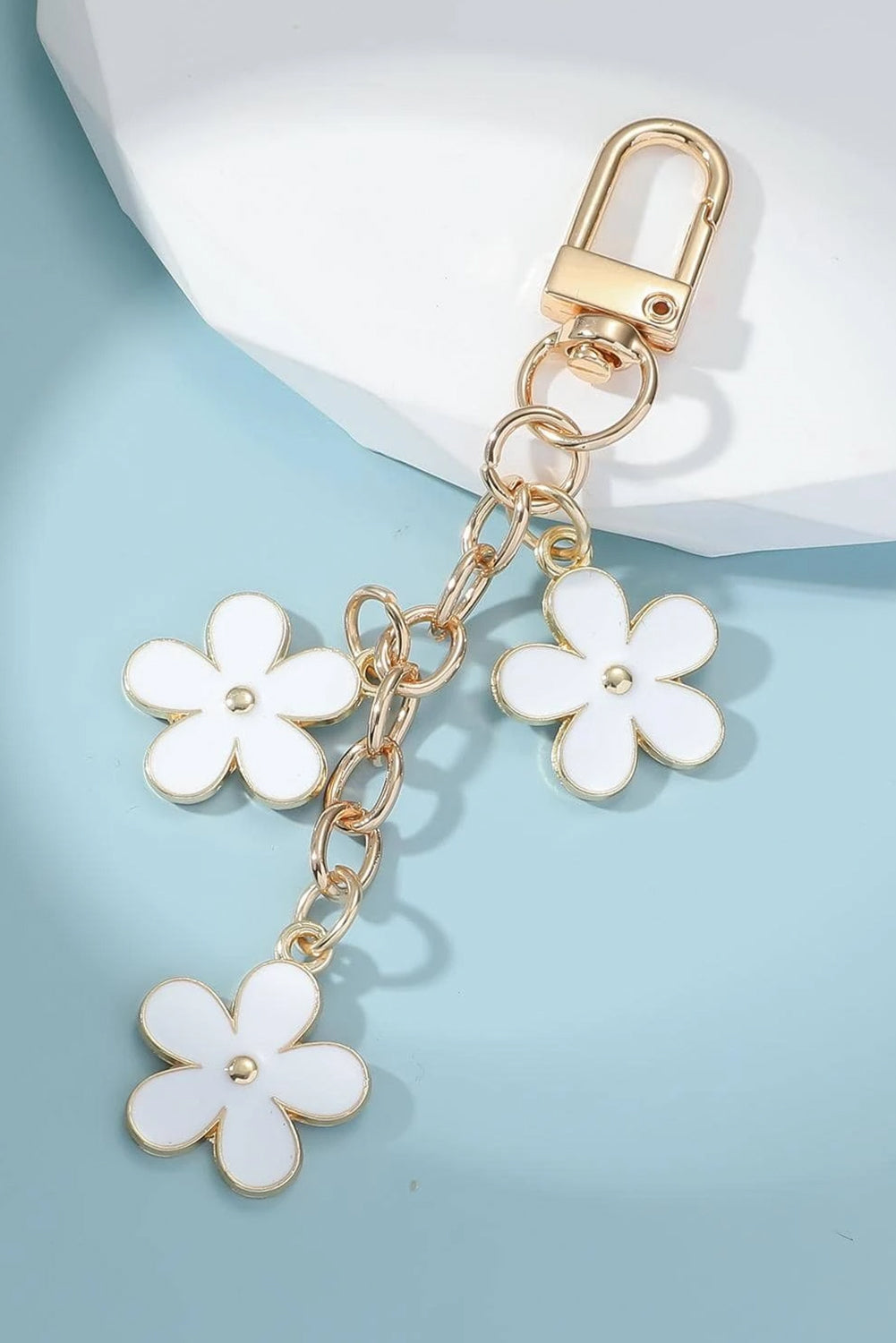 Keychain with white flowers on a light blue background
