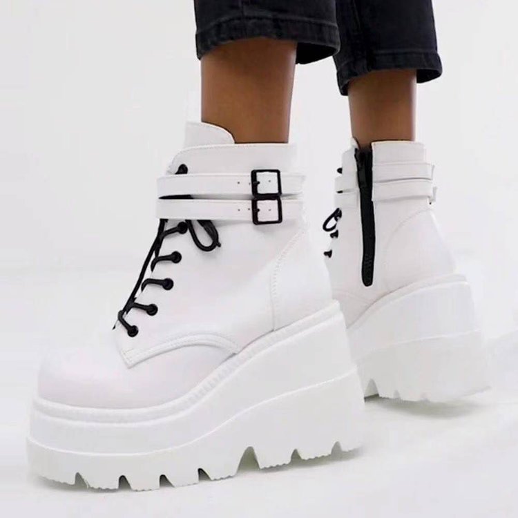 White platform boots with black buckles on a white background