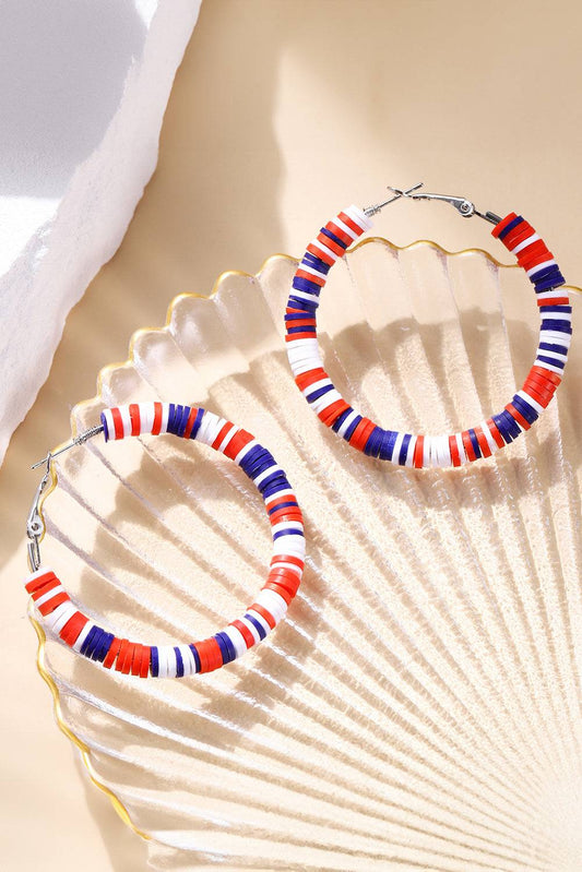 Colorful beaded hoop earrings on a shell background