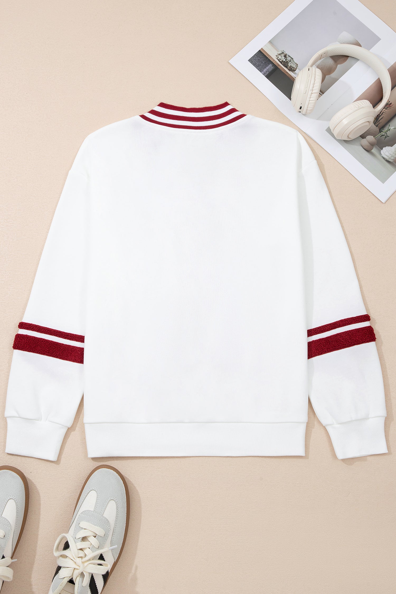 White sweater with red stripes on a beige background