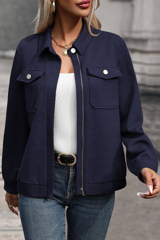 Person wearing a navy blue jacket with a blurred background