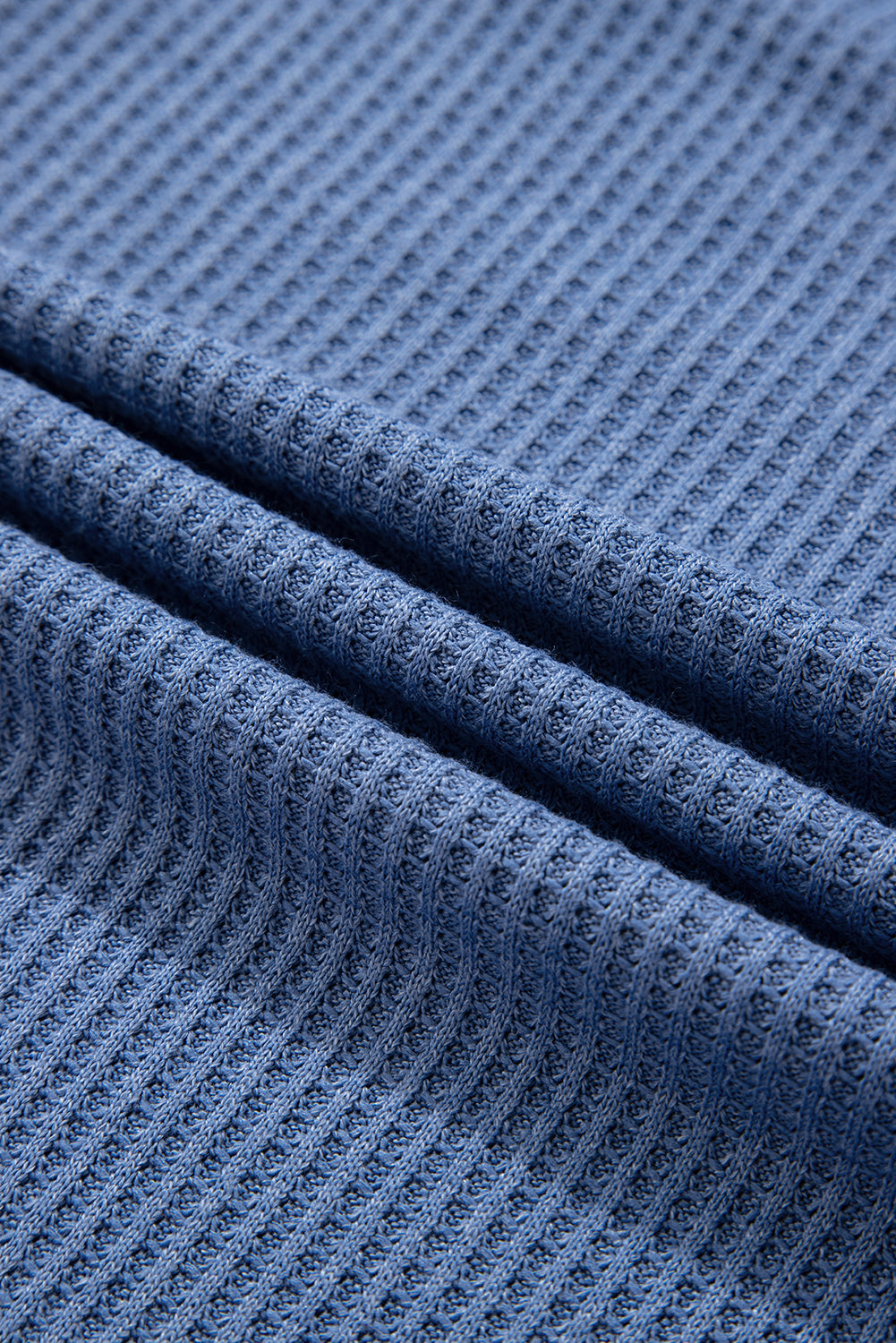 Close-up of textured blue fabric with a subtle pattern