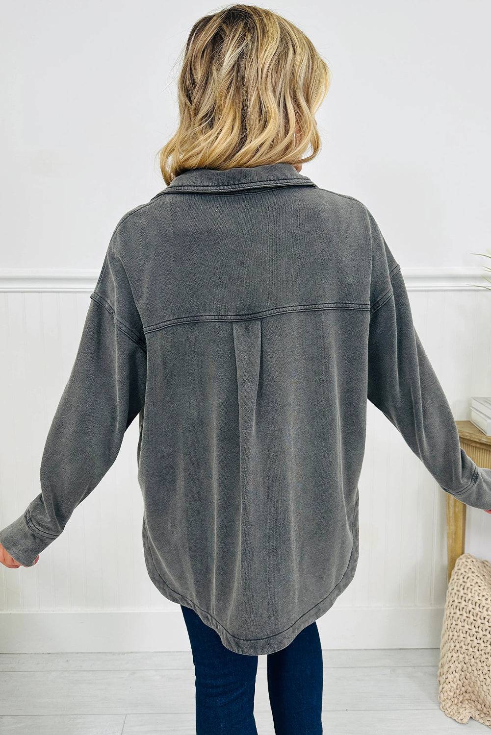 Person wearing a gray oversized shirt with a white background