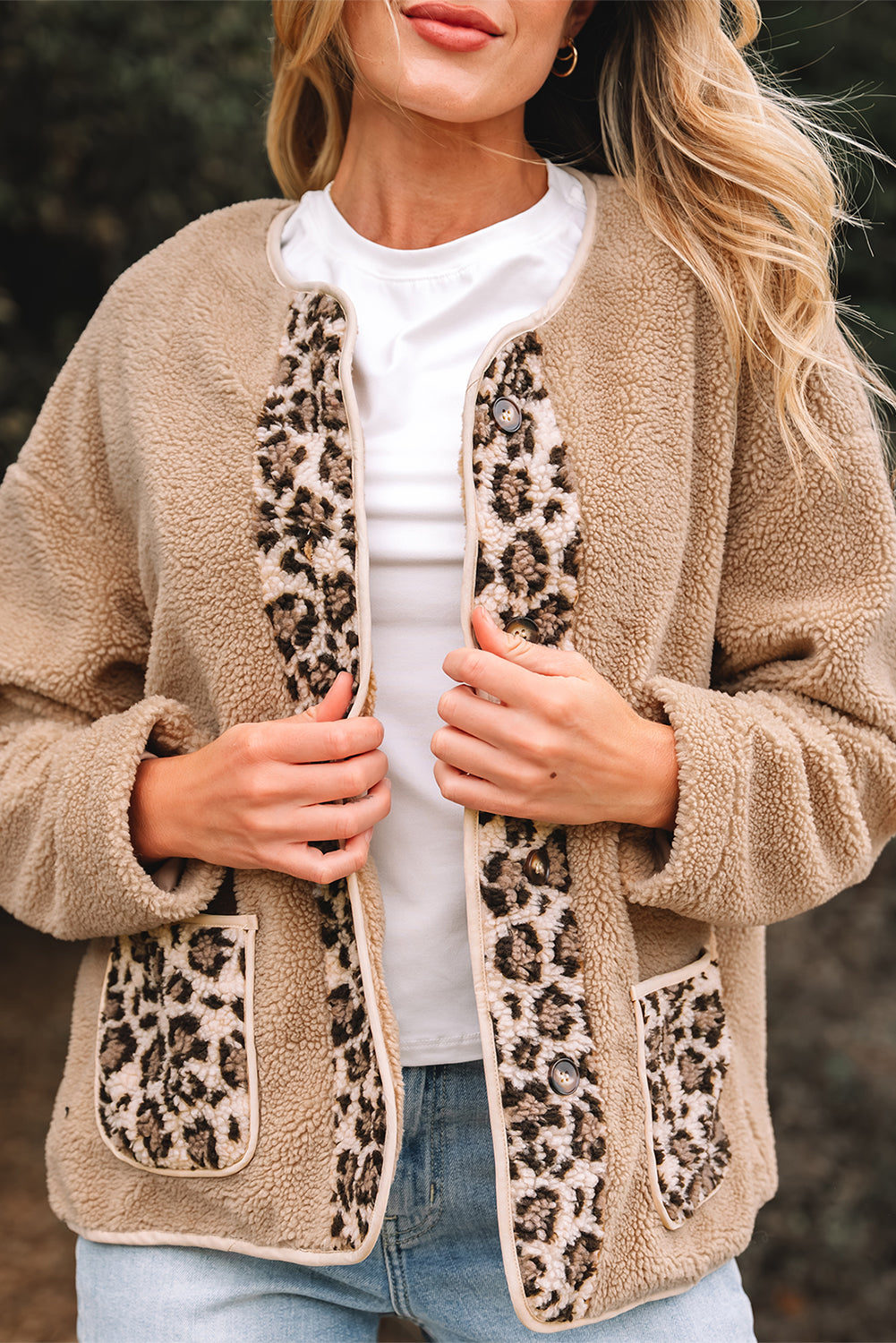 Beige fleece cardigan with leopard print pockets worn by a person.