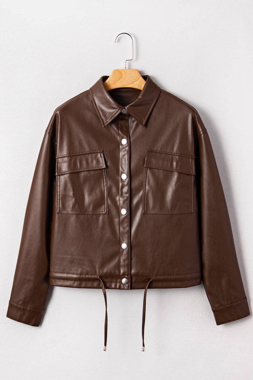 Brown leather jacket on a hanger against a white background