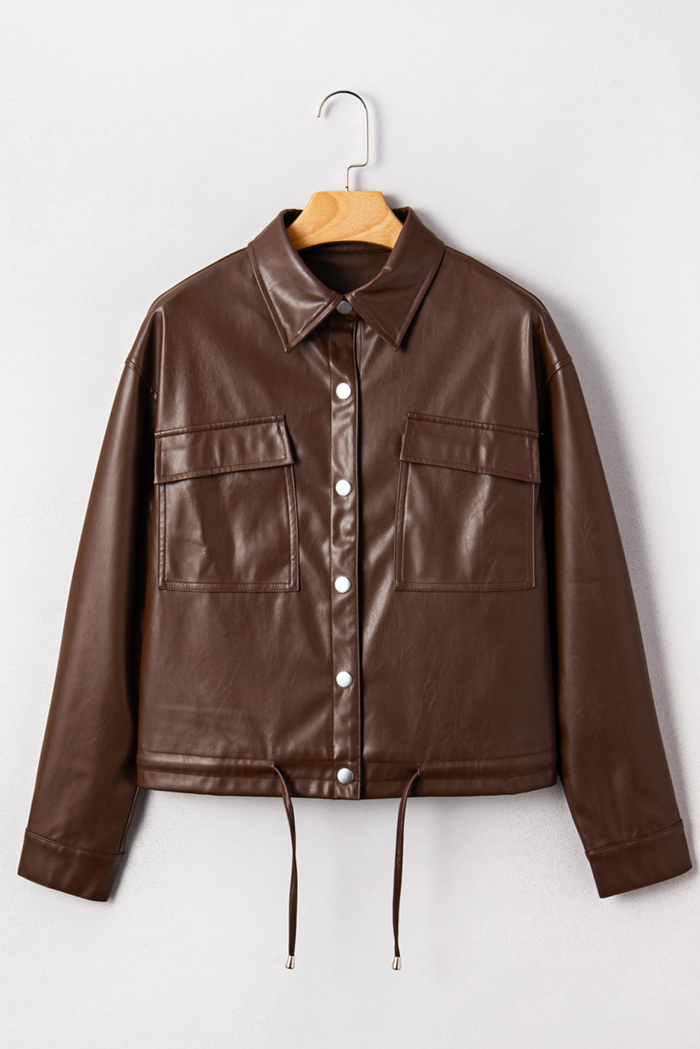 Brown leather jacket on a hanger against a white background