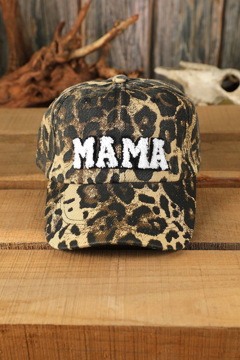 Leopard print cap with 'MAMA' text on a wooden surface