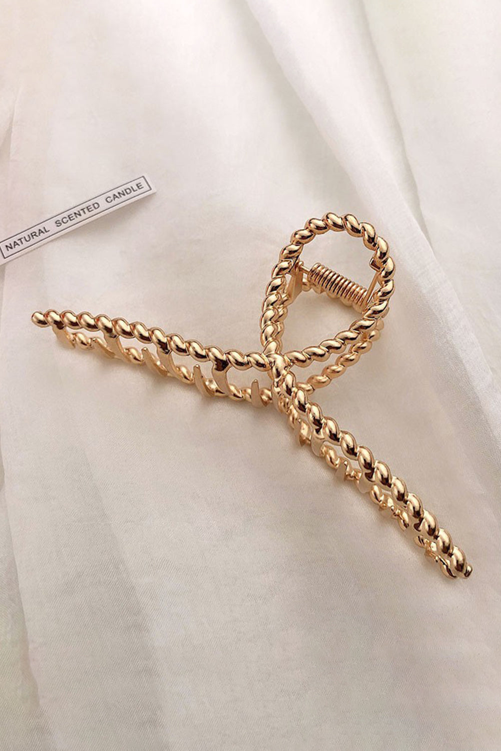 Gold chain tie on a white fabric background