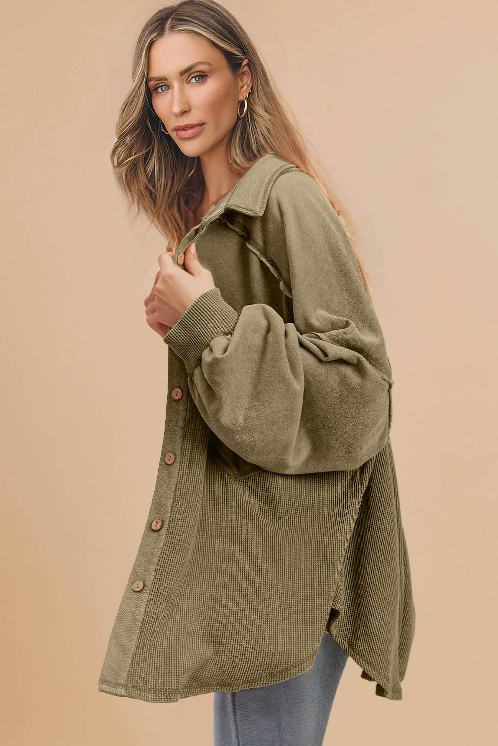 Woman wearing an olive green cardigan against a beige background