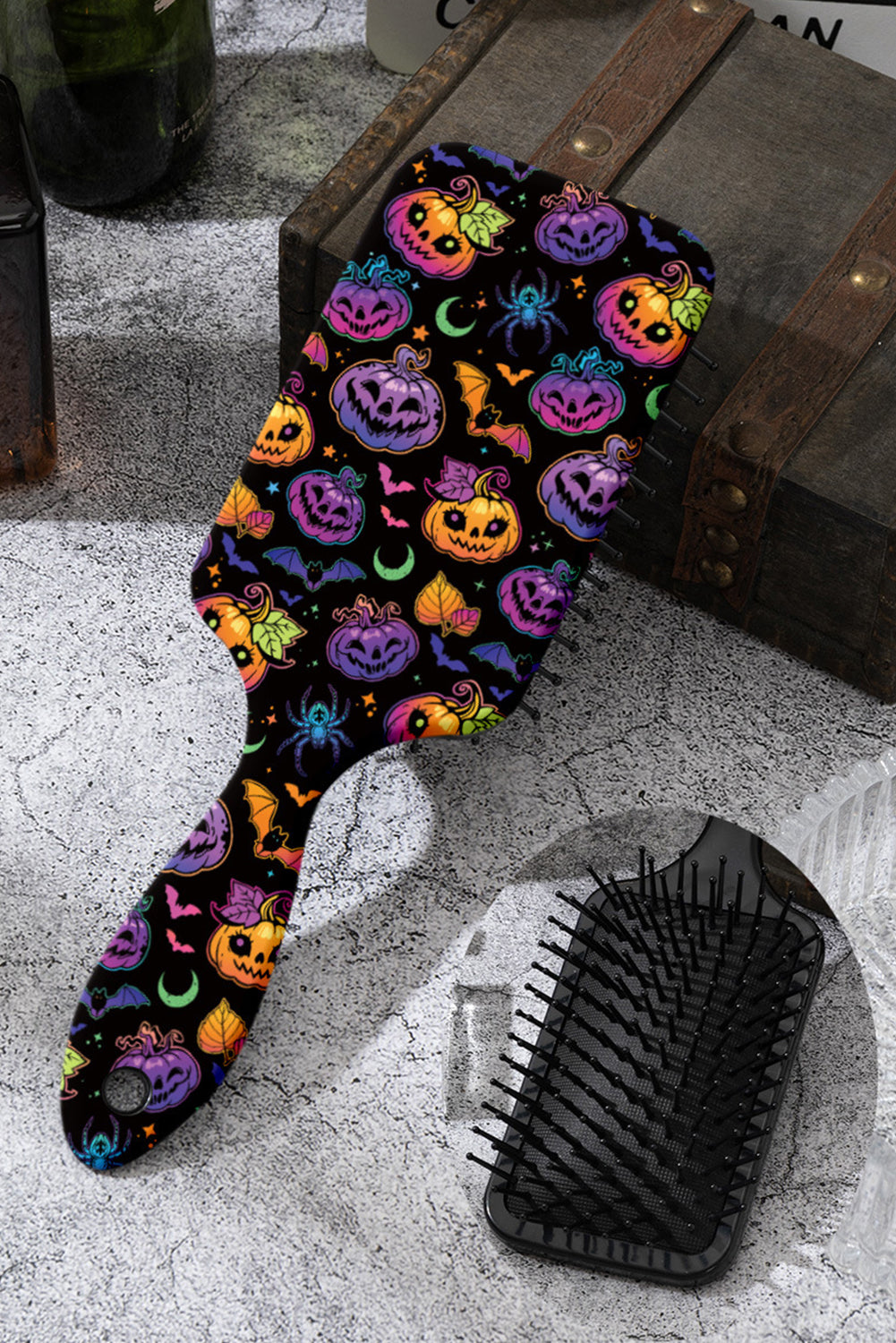 Halloween-themed hairbrush with colorful designs on a textured surface.