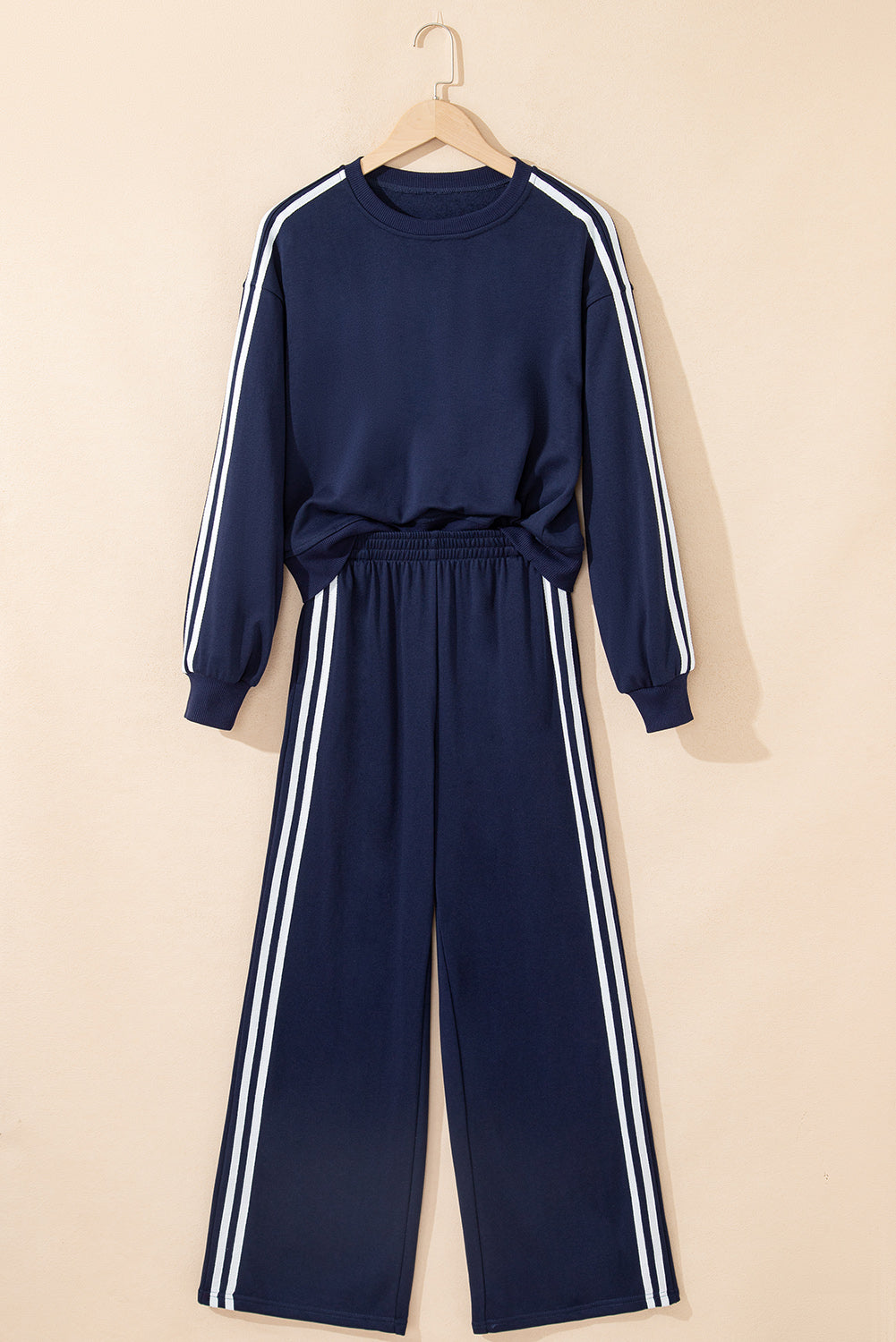 Navy tracksuit with white stripes on a beige background
