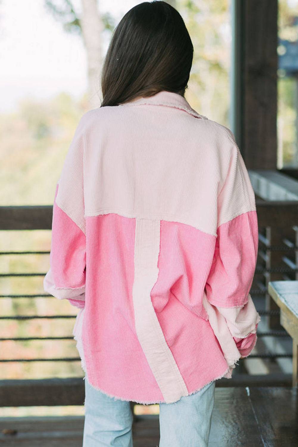 Person wearing a pink and beige jacket with a blurred background