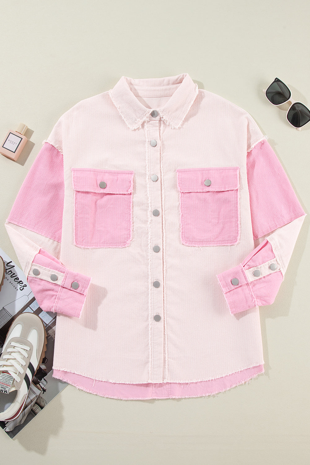 Pink denim jacket with two front pockets on a light gray background