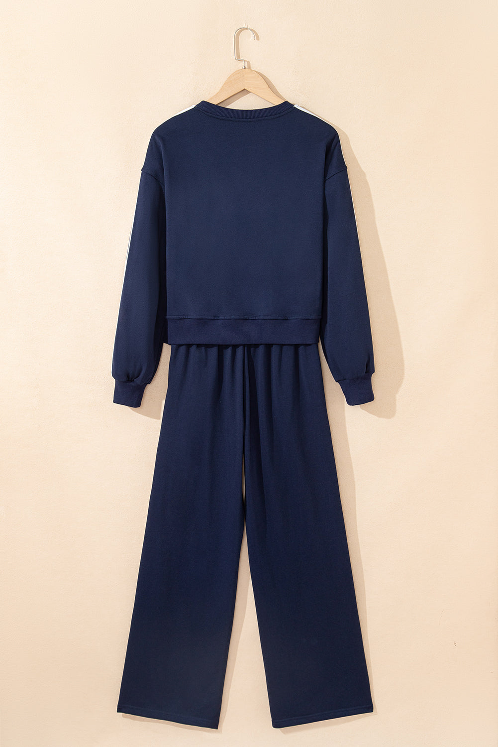 Navy blue outfit with a top and pants on a beige background