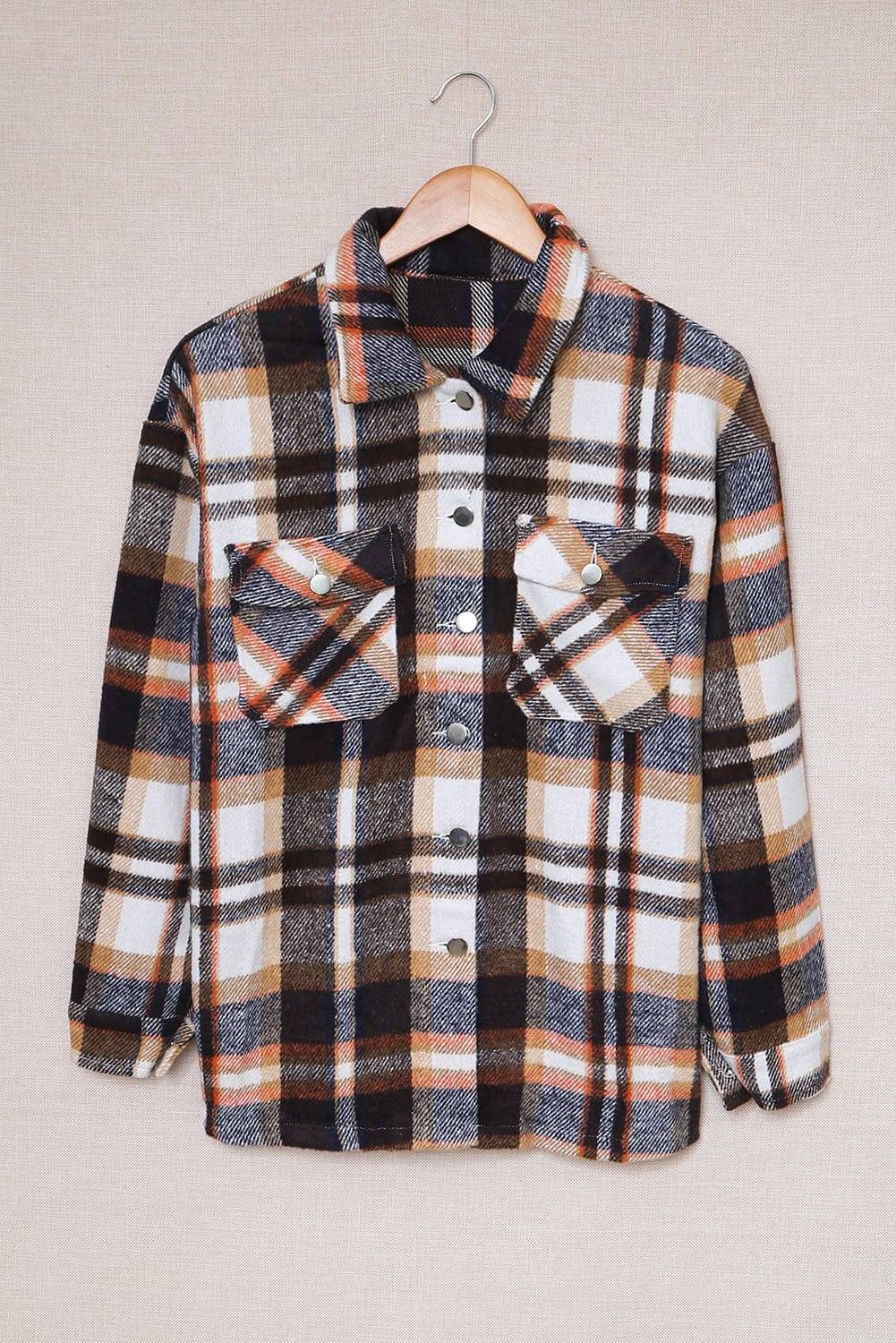 Plaid shirt on a hanger against a plain background