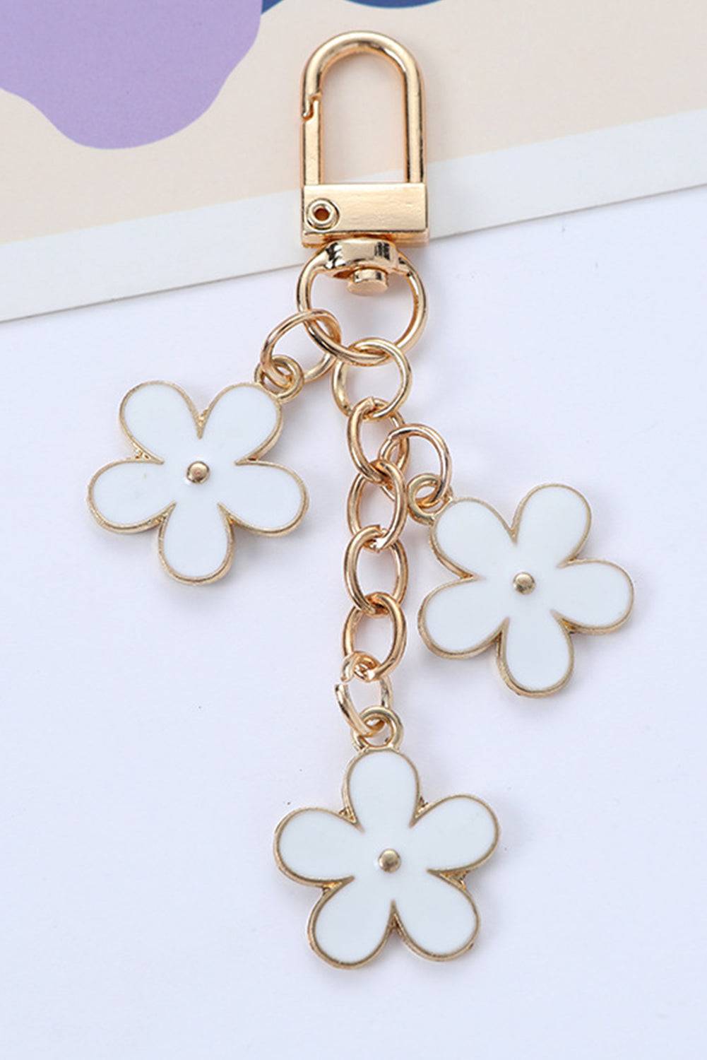 Flower-shaped keychain with gold clasp on a white background