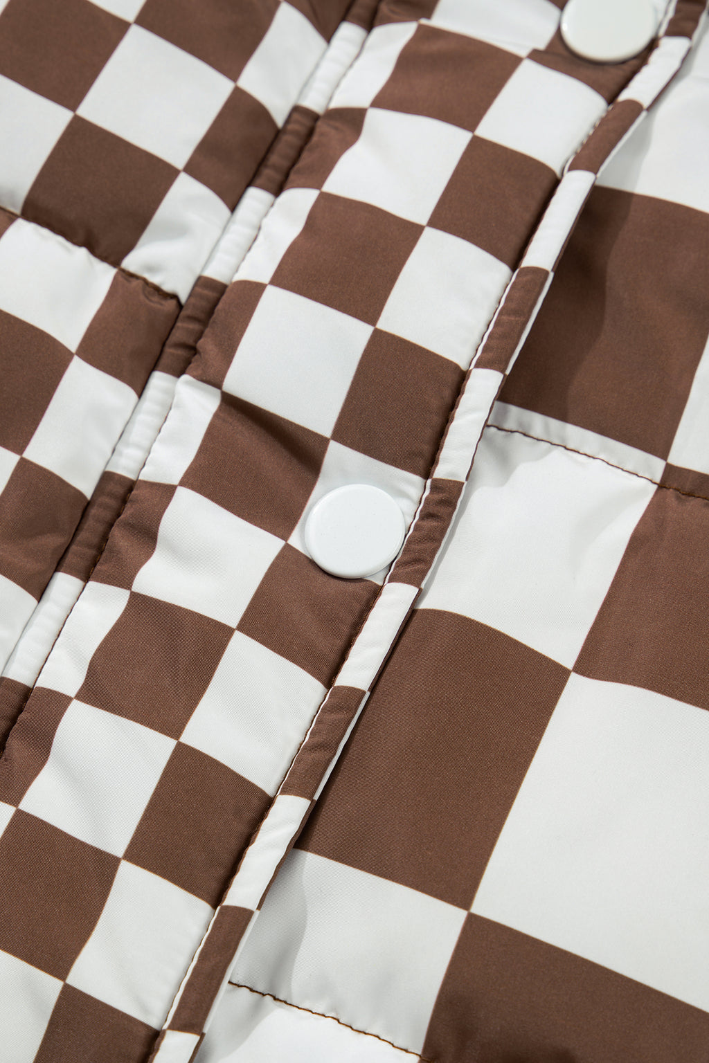 Close-up of a brown and white checkered fabric with buttons.