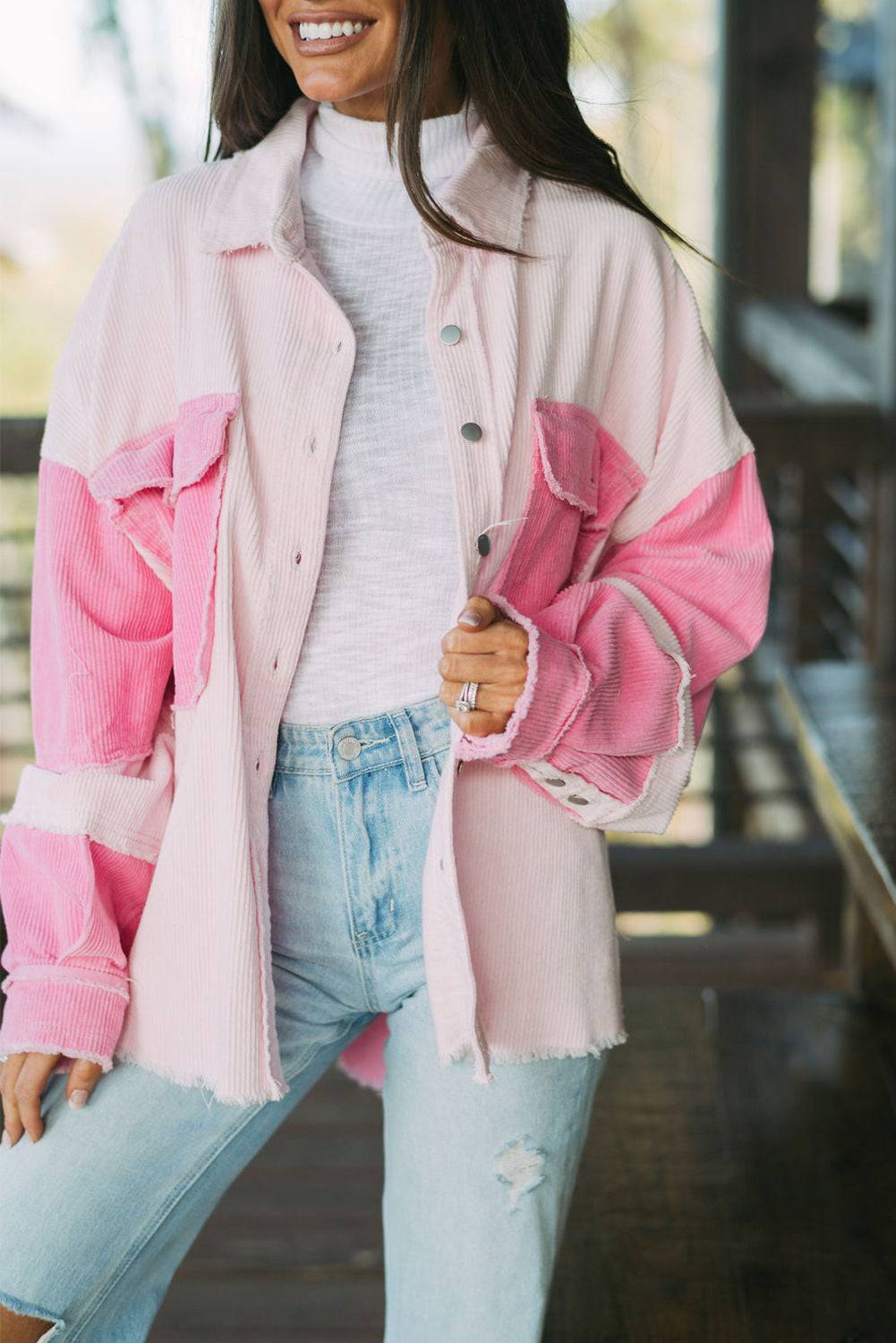 Woman wearing a pink and white jacket with a blurred background