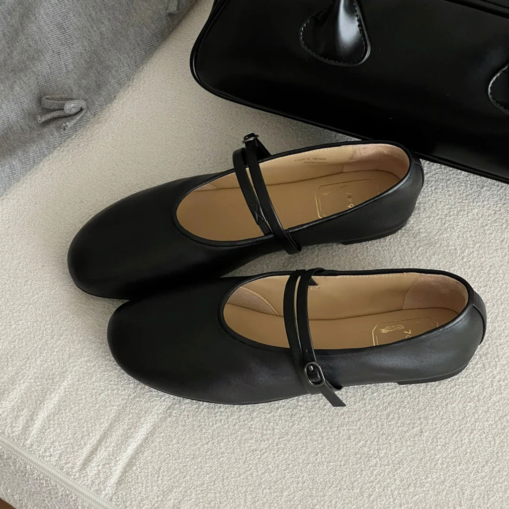 Black shoes with a strap on a textured surface