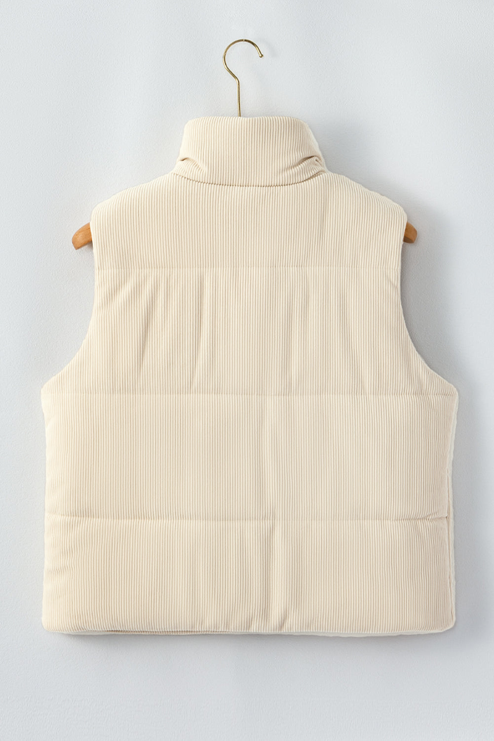 Beige puffer vest on a hanger against a light gray background