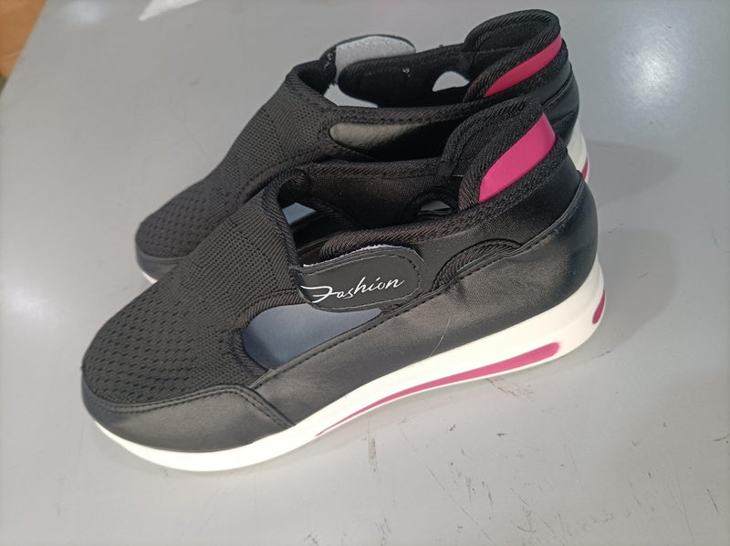 Black and pink high-top sneakers on a gray surface