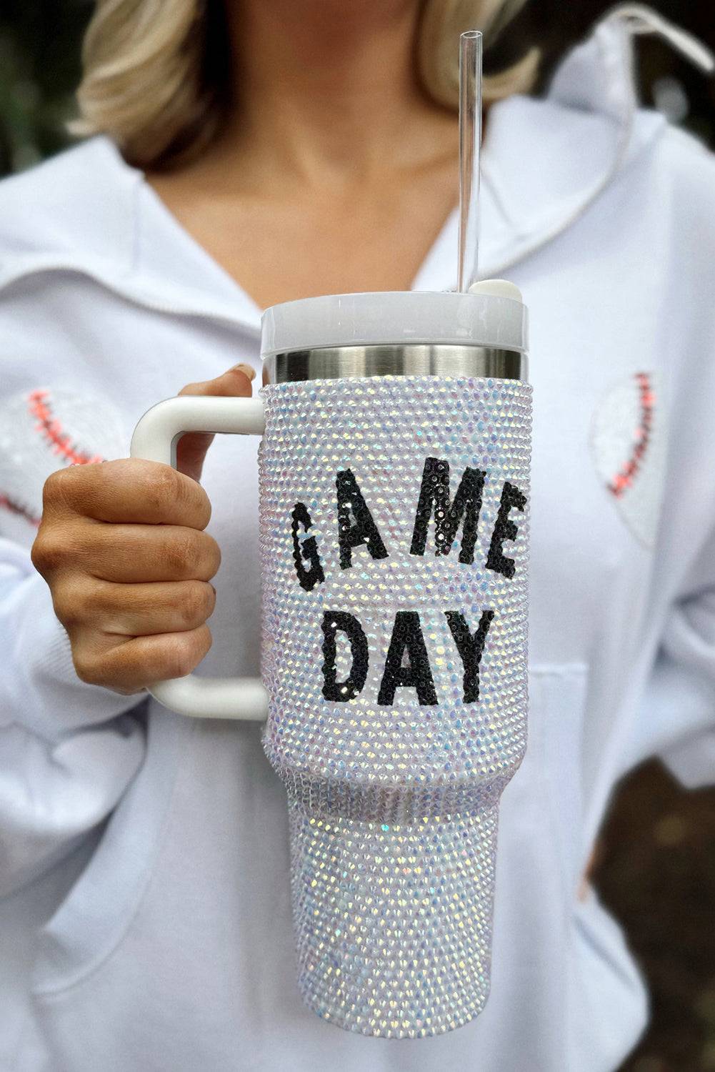 Person holding a blinged-out tumbler with 'GAME DAY' text