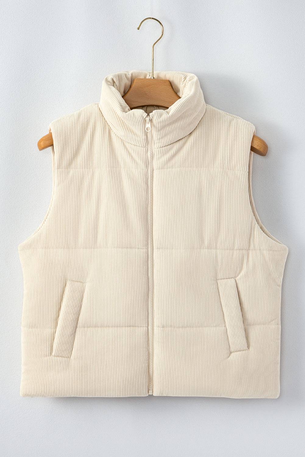 Beige puffer vest on a wooden hanger against a light gray background