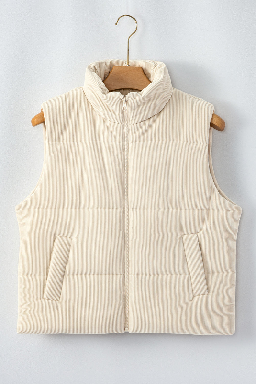 Beige puffer vest on a wooden hanger against a light gray background