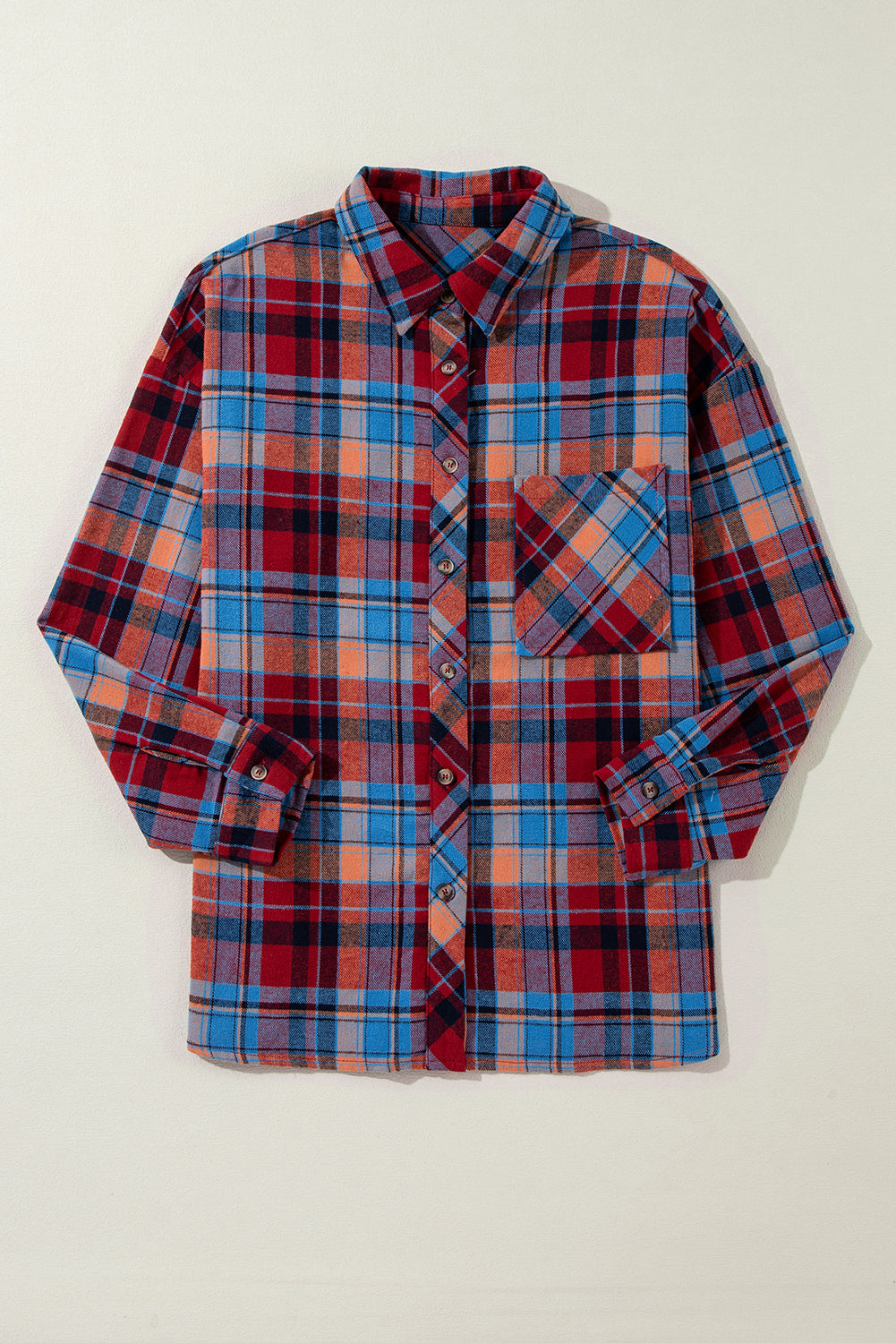 Plaid shirt with red, blue, and orange pattern on a beige background
